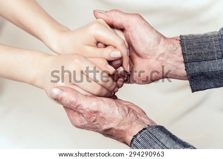 Hands of the old man and a young woman. toning