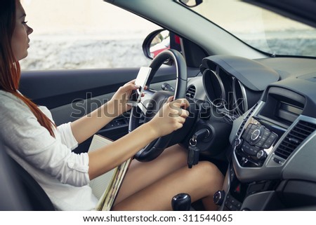 Woman working at the wheel in the car. don't text and drive