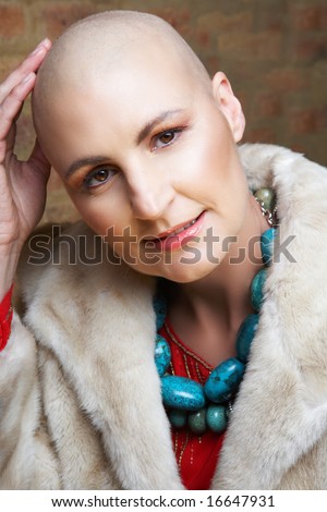 Beautiful happy bald woman in fake fur coat and turquoise necklace
