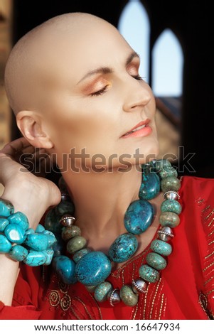 Beautiful happy bald woman in turquoise necklace enjoying the sunlight - shot in natural light