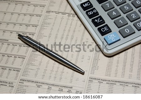 Professional calculator, steel pen and financial newspaper. Business concept.