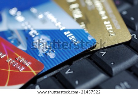 Credit cards laying on laptop keyboard close up photography.