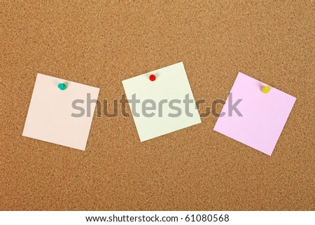 Three note papers attached to cork board with pins.