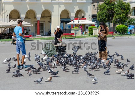 THESSALONIKI, GREECE - AUGUST 13, 2014: Young man and woman are feeding pigeons in the square of Aristotle in Thessaloniki, Greece