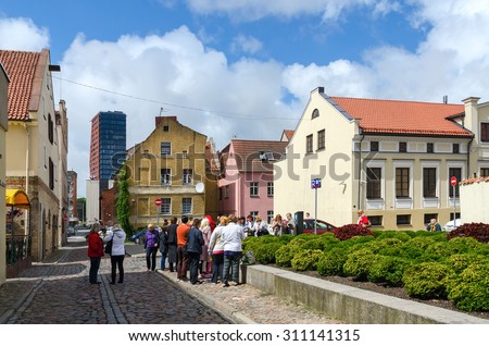 KLAIPEDA, LITHUANIA - JULY 11, 2015: Unidentified tourists see the sights in the street of the Old Town in Klaipeda