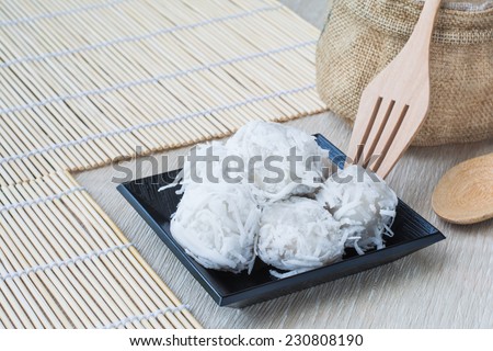 Coconut dessert with white topping on wood background