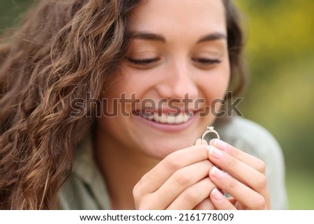 Close up portrait of a happy woman looking at her engagement ring in a park Foto stock © 