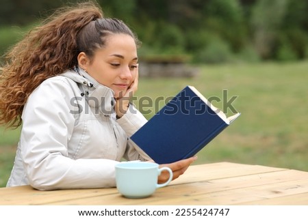 Similar – Image, Stock Photo Interested woman reading book at window sill at home