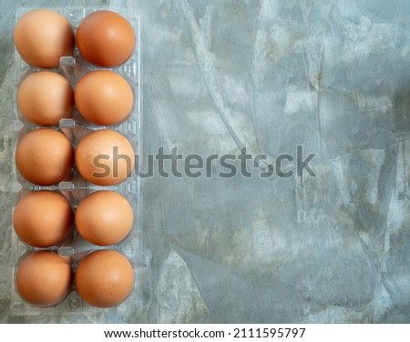 Close-up Happy Easter view fresh brown chicken raw egg several in egg box plastic on a table cement pattern Loft color
 for cooking. Healthy eating