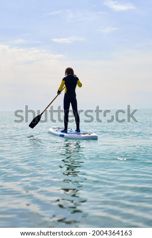 Image, Stock Photo Pensive man with paddle board before surfing