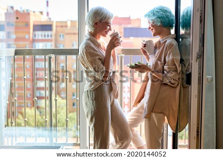 lesbian, couple, breakfast, romance concept. beautiful caucasian lesbian women have breakfast on balcony having talk, enjoying morning together. side view portrait, copy space. people lifestyle