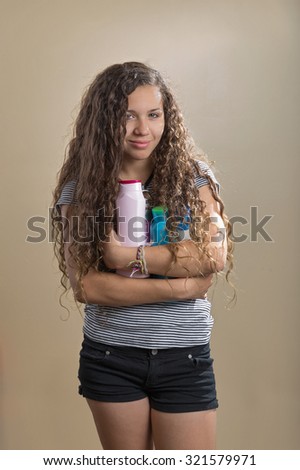Teenager smiles at camera while holding hair products