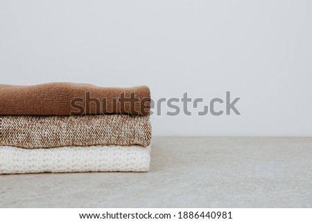 Similar – Image, Stock Photo Women fashion composition. Warm winter female woollen knitted sweaters, pullovers stack on a wooden stool at white background. Modern clothes concept for magazine, blog, social media.
