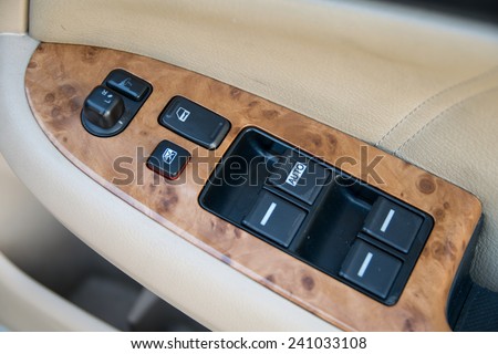 car interior details of door handle with windows controls and adjustments. Car window controls