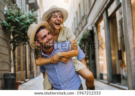 Couple of tourists having fun walking on city street at holiday - Happy friends laughing together on vacation - People and holidays concept 