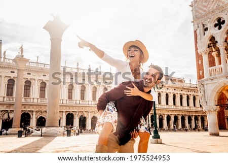 Couple of tourists on vacation in Venice, Italy - Two lovers having fun on city street at sunset - Tourism and love concept
