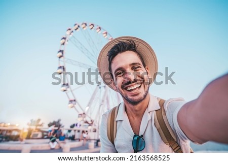Happy man taking selfie walking on city street - Male tourist having fun on summer vacation - Smiling guy looking at camera outside - Focus on eye Foto stock © 