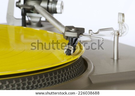 Vintage record player playing a yellow vinyl record