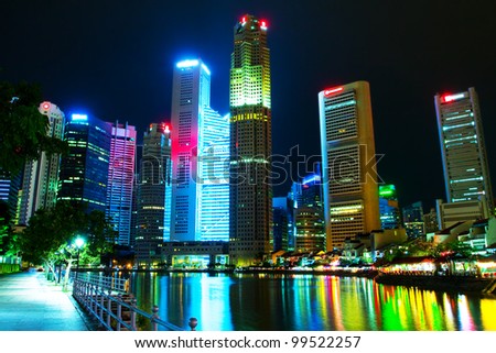 Singapore\'s downtown skyscrapers reflected on water at night  (Night panorama of the city in the artificial lighting)