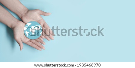 Hands holding smile earth paper cut, save planet, earth day, sustainable living, ecology environment, climate emergency action, world environment day concept, illustration for global warming content