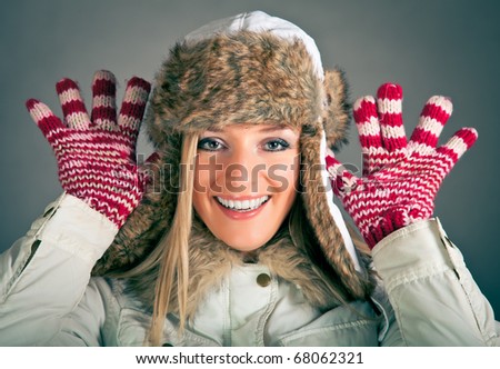 Portrait of beautiful blond woman in warm clothes on blue background