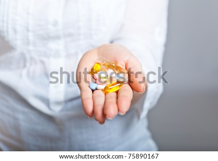 Woman holding pharmaceuticals on neutral