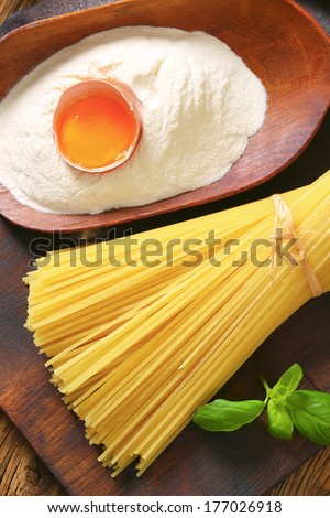 Bakery ingredient, pasta, flour, egg and tomato on a cutting board