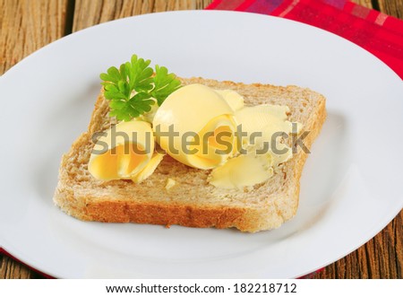 Slices of toast bread with butter on wooden table