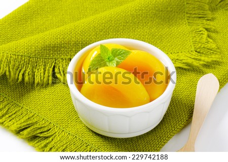 Canned yellow peach in porcelain bowl