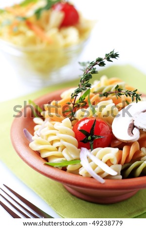 Tricolor corkscrew pasta in a terracotta bowl