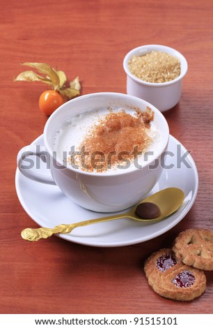 Cup of hot milk with brown sugar and cookies
