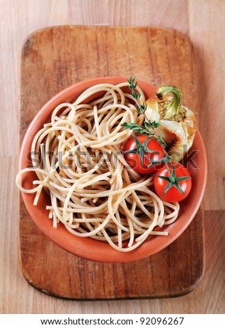 Cooked whole wheat spaghetti in a terracotta bowl