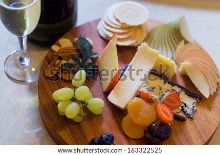 Overhead view of a cheese and fruit platter with sparkling wine