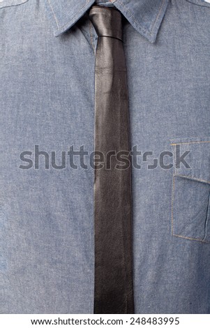 Close up of mans shirt and thin black leather tie