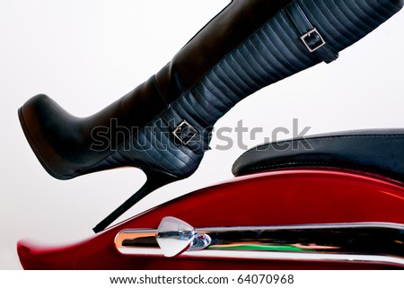 Female wearing black knee high Leather Boot on motorbike