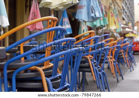 Colorful  aluminum chairs stacked outside at a cafe outdoor dining area