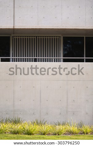 Green plants in focus with concrete building in background