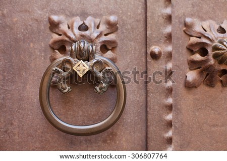 Ornate metal door knocker on metal door, Barcelona, Spain