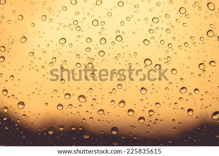 Natural water drops on orange colour  window glass background