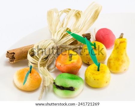 Colorful sweet marzipan fruits with cinnamon spicy stick decoration, candies dessert