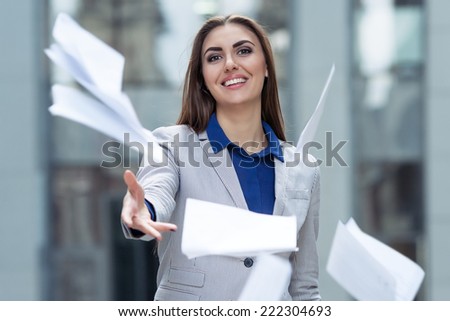 business woman throwing papers on the background of the business center