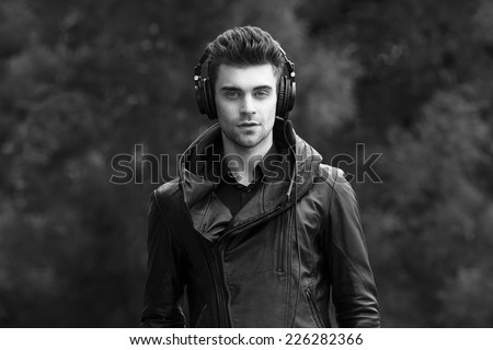 man in headphones on the street. admiring the autumn nature. black and white
