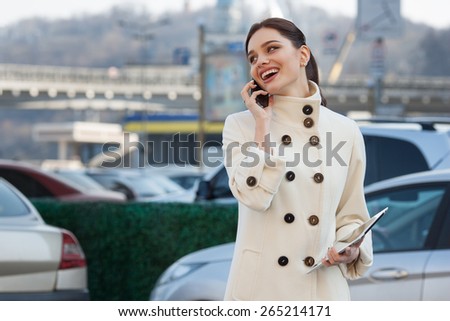 businesswoman with a tablet in his hand talking on the phone over city background