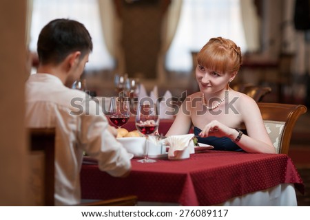 Attractive casual young couple drinking a glass of wine in a restaurant. Lovers having a date or romantic dinner in a fancy restaurant