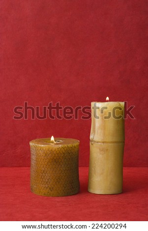 Two pillar candles, side by side, burning