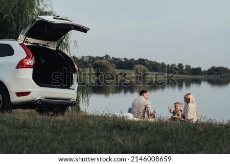 Similar – Image, Stock Photo Happy young family near lake, pond. Family enjoying life together at meadow. People having fun in nature. Family bonds outside. Mother, father, child smiling while spending free time outdoors