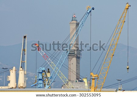 GENOA, ITALY - JULY 21, 2015: The cranes of the harbor and the lighthouse symbol of the historic maritime city of Genoa.