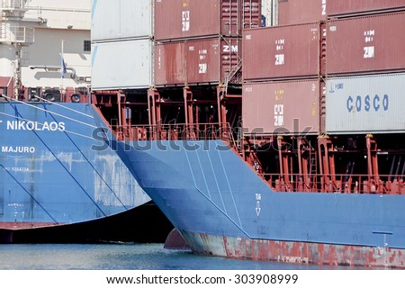 GENOA, ITALY - JULY 20, 2014: Cargo ships with containers on board the commercial port of Genoa.