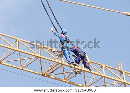 ITALY - MARCH 2014: Construction workers to work in a large urban yard. Dismantling of the crane.
