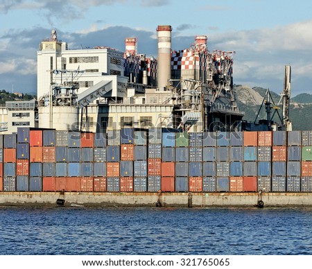 GENOA, ITALY - SEPTEMBER 24, 2015: the coal power plant of the Enel in Genoa port. Containers and silos on the dock in front of the power plant.